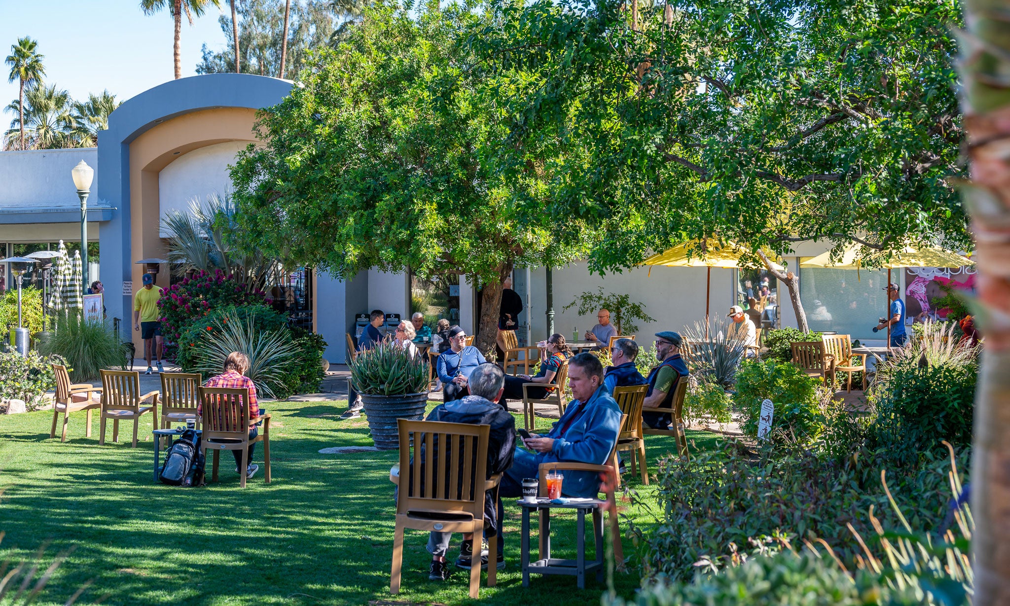 Koffi Coffee Palm Springs North Corridor with lush green trees and seating